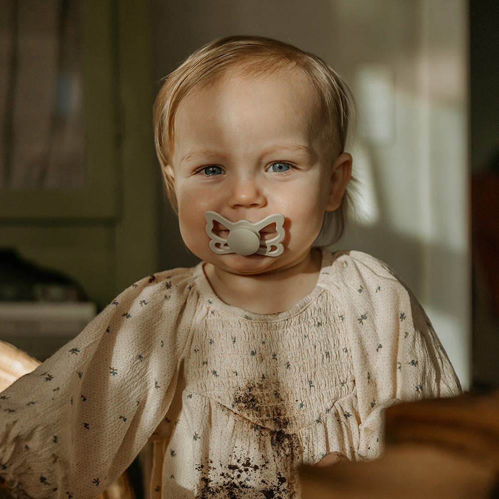 Frigg® Anatomska Duda iz silikona Butterfly Silky Satin/Cream (6-18m) FRIGG